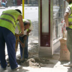 Un grup de treballadors de la construcció realitza arranjaments a la via pública