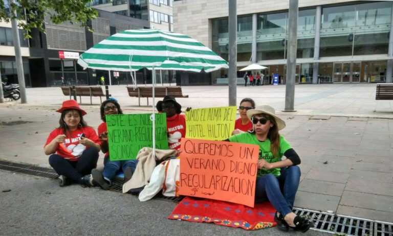 Un grup de cambreres de pis reclama ser regularitzades mentre al fons l'hotel entrevista aspirants a treballar foto: Tomeu Ferrer