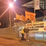 Treballadors de Nestlé fixen una pancarta a la porta de la fàbrica, foto: UGT Girona
